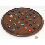 Toy: A 19thC mahogany solitaire board with 32 coloured marbles , many handmade.