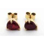 A pair of gold stud earings set with rubies.