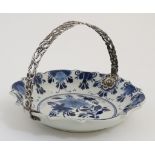 A 20thC Delft style blue and white bon bon dish decorated with flowers and having white metal swing