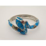 A silver bangle bracelet formed as a snake with turquoise and pink stone decoration
