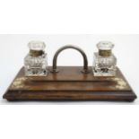 A late 19thC inkstand / Standish having 2 glass inkwells with hinged lids.