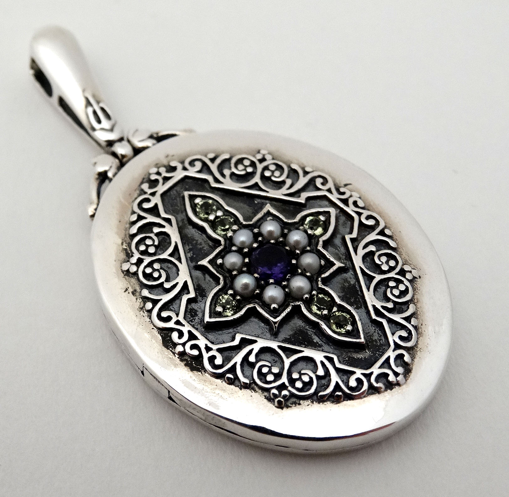 A Sterling silver locket set with peridot, amethyst and seed pearls. - Image 3 of 5