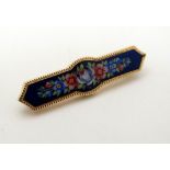 A yellow metal brooch with floral enamel decoration to centre CONDITION: Please