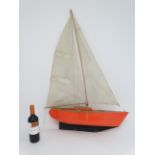 Toy: A Bermuda rigged pond yacht with fabric sale and red painted wooden hull. 41'' high.