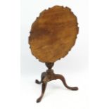 A Geo III mahogany tilt top tripod supper table .