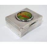 A silver table top cigarette box with engine turned decoration and image of golfer to lid.