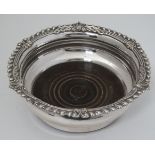 A late 19thC / early 20thC silver plate coaster with turned wooden base 7" diameter