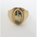 A 9ct gold ring set with moss agate cabochon CONDITION: Please Note - we do not