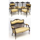 A late Victorian black walnut salon suite comprising 2 open armchairs,