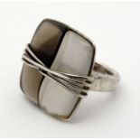 A silver ring of abstract modernist design set with smoky and white glass and banded silver
