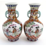 A pair of Oriental vases having panels decorated with female figures in a garden scene ,