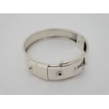 A silver bangle bracelet formed as a belt with buckle CONDITION: Please Note - we