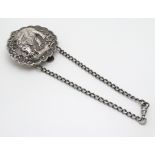 A white metal Chatelaine clip decorated with Indian hunting image depicting figure elegant and