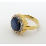 A 14ct gold ring set with cabochon star sapphire to centre bordered by diamonds