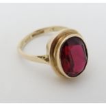 A 9ct gold ring set with large facet cut red stone CONDITION: Please Note - we do