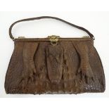 An early 20thC vintage ladies large crocodile skin handbag with head and foot decoration,