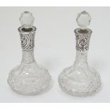 A pair of cut glass scent bottles with silver collars hallmarked Birmingham 1908 maker Gourdel