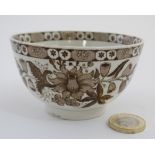 A 19thC small brown and white tea bowl with floral decoration. 2 1/2'' high.