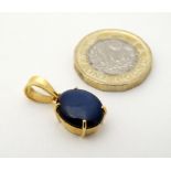 A 9ct gold pendant set with sapphire cabochon approx 1" long CONDITION: Please Note