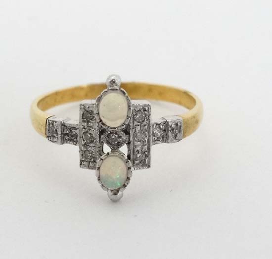 A silver gilt ring set with 2 opal like cabochon and white stones in an Art Deco style setting.