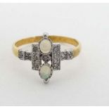 A silver gilt ring set with 2 opal like cabochon and white stones in an Art Deco style setting.