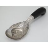 A white metal spoon with engraved foliate and dragon decoration with shaped horn handle.