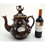 A 19thC large Bargeware / Measham teapot decorated with traditional design on a brown glazed body,