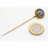 A 19thC gilt metal stick pin surmounted by Essex Crystal reverse glass intaglio depicting the head