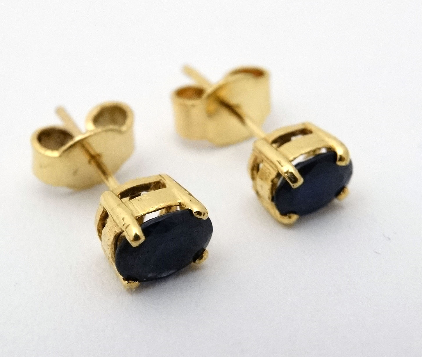 A pair of sapphire stud earrings with yellow metal mounts CONDITION: Please Note -