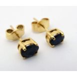 A pair of sapphire stud earrings with yellow metal mounts CONDITION: Please Note -