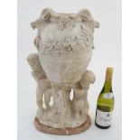 An 18thC/ 19thC carved marble urn on stand depicting a pair of putti holding a wine urn with vine