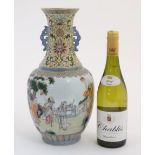 A large Chinese famille rose twin handled vase, decorated with figures in a garden scene,