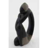 An Oriental soapstone carving of a figure sat with knees up and with scrafito carving.