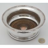 A late 19thC / early 20thC silver plate coaster with turned wooden base 6" diameter