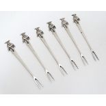 A set of 6 white metal savoury forks with South American figures to top.