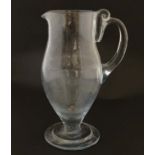 Withdrawn from Auction A tall clear glass pedestal jug with loop handle 11" high