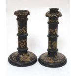 A pair of late 19thC ebonised and applique turned wood decorated candlesticks.
