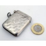 A silver vesta case with engine turned decoration, hinged lid and striker under.