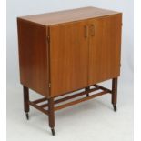 Vintage Retro : An English Teak record cabinet on castors having 2 doors opening to reveal fitted