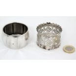 A silver plate napkin ring with pierced decoration together with a white metal example (2)