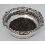 A late 19thC / early 20thC silver plate coaster with turned wooden base 7" diameter