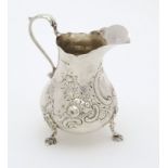 A Victorian silver jug with embossed decoration.