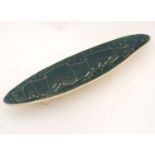 An elongated ceramic dish decorated with musical notes in cream on a green ground. 16'' long.