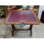 A Victorian stained oak card table with fold over and twist top and gold tooled burgundy leather