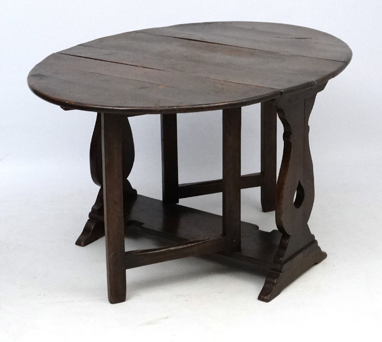 An early 20thC oak table of oval drop flap gate leg form 51 1/2" wide (open) x 38" long x 29" high