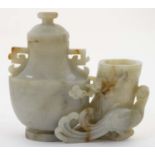 A Chinese jade pot and cover formed as a fire bird beside a tree trunk and lidded urn.