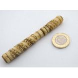 A 19thC carved bone needle case opening to reveal 6 assorted steel needles within.