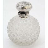 A cut glass scent / perfume bottle of spherical form with silver mounts and top hallmarked