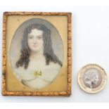 A c.1840 oval watercolour miniature on ivory of a young woman. Within a gilt frame.