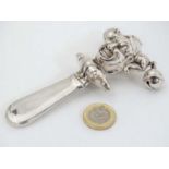 A white metal child's rattle with Jester decoration and twin bells. marked Sterling.